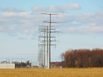 Wind turbines on field against sky