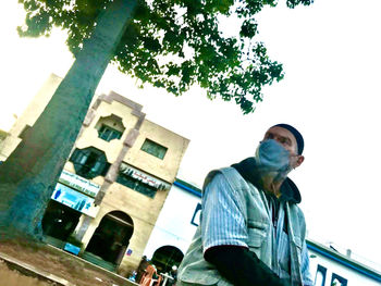 Low angle view of man and buildings against clear sky