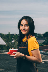 Portrait of a smiling young woman holding ice cream