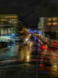 Blurred motion of illuminated city against sky at night