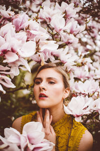 Young woman amidst pink flowers during springtime