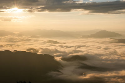 Aerial view of clouds over mountains during sunset