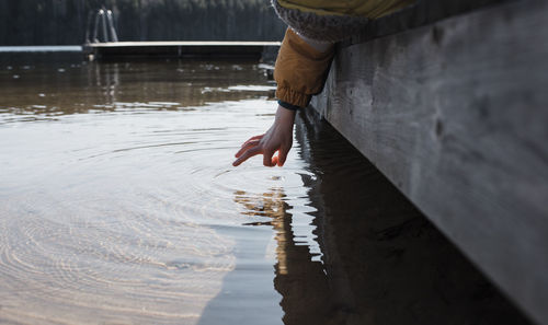 Child's hand flicking sea water at the beach in sweden