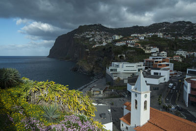 Scenic view of townscape by sea against sky