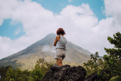 Rear view of woman looking at mountain against sky