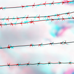 Low angle view of barbed wire against sky