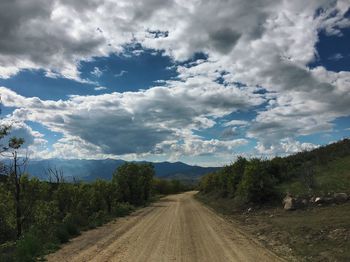 Dirt road along landscape and against sky
