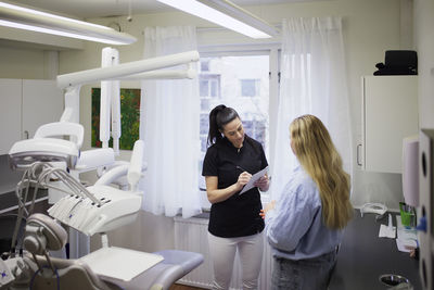 Female dentist talking to patient in office