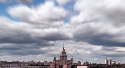 Buildings in city against cloudy sky