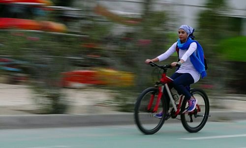 Blurred motion of woman riding bicycle