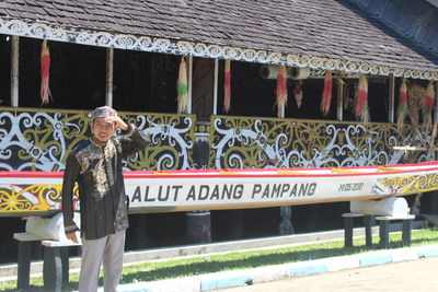 Portrait of smiling standing against built structure