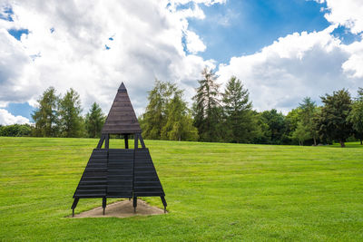 Gazebo on grassy field against sky