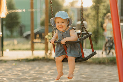 Portrait of boy swinging at playground