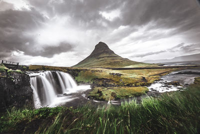 Scenic view of waterfall against sky