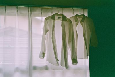 Shirts hanging against window at home