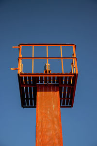 Low angle view of metallic structure against clear blue sky