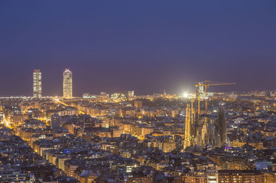 Illuminated buildings in city against sky at night