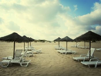 Scenic view of beach against cloudy sky