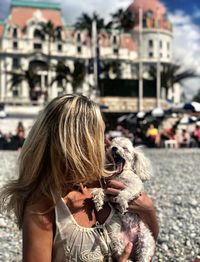 Woman holding dog at beach