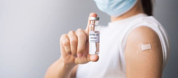 Close-up of woman holding hands over white background