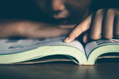 Close-up of hand on book