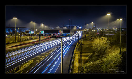 Illuminated bridge in city against sky at night