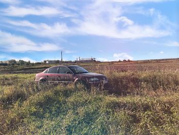 Abandoned truck on field against sky