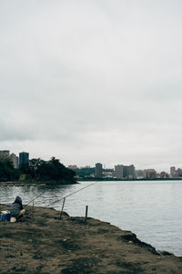 Scenic view of sea by buildings against sky