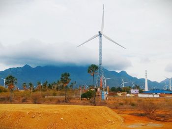 Traditional windmill on field against sky