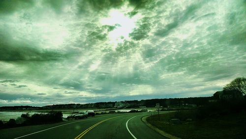 Empty road against cloudy sky