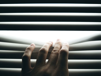 Hand is pushing closed blinds