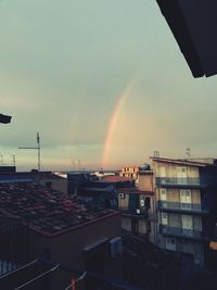 Rainbow over buildings in city