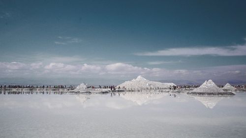 People of on snow field against sky