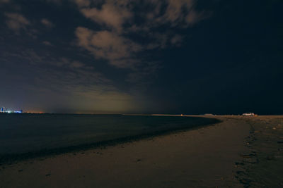 Scenic view of beach against sky at sunset