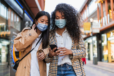 Young woman using mobile phone in city