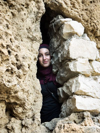 Portrait of young woman standing on rock formation