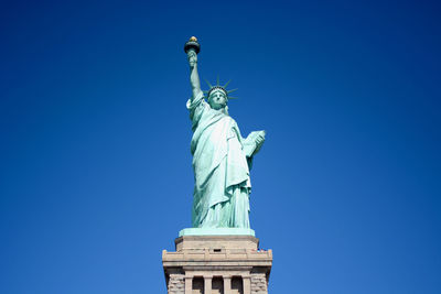 Low angle view of statue against blue sky