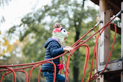 Side view of girl wearing warm clothing playing in playground