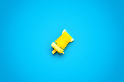 High angle view of yellow umbrella on blue background