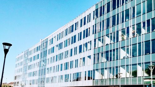 Low angle view of modern building against blue sky