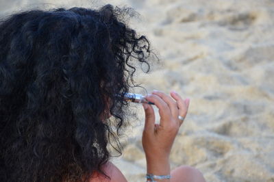 Close-up of woman holding hands at beach