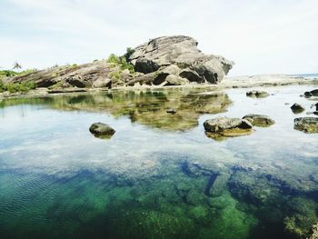 Rocks in sea against sky