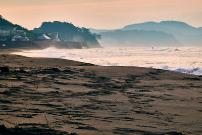 Scenic view of beach against sky during sunrise