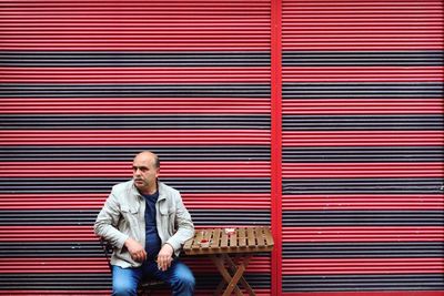 Full length of man sitting outdoors