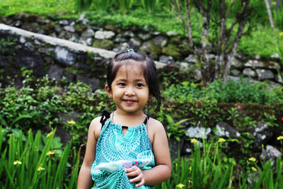 Cute smiling girl looking away while standing outdoors