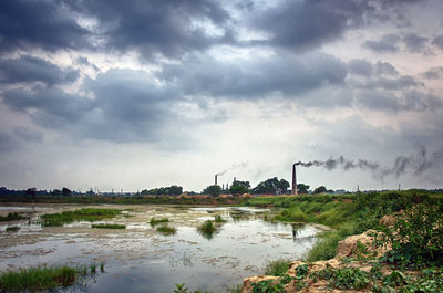 Scenic view of factory against sky