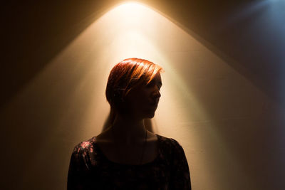 Rear view of woman standing against wall