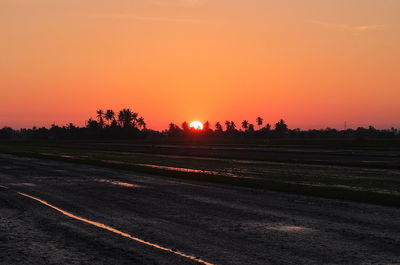 Scenic view of silhouette landscape against orange sky