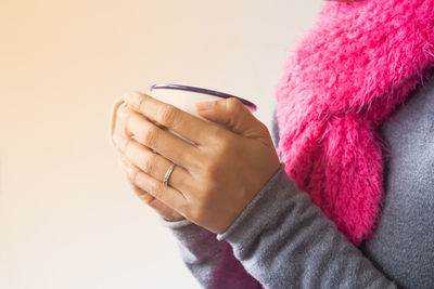 Close-up of woman hands holding coffee cup at home