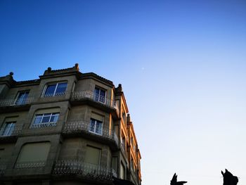 Low angle view of building against clear blue sky